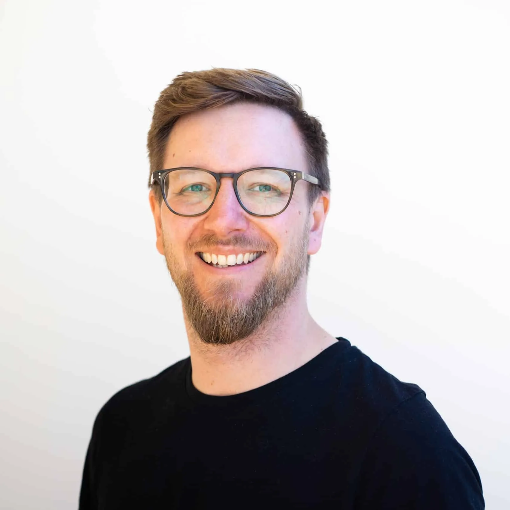 Sören Elser, ElevateX co-founder, smiling in front of a light background